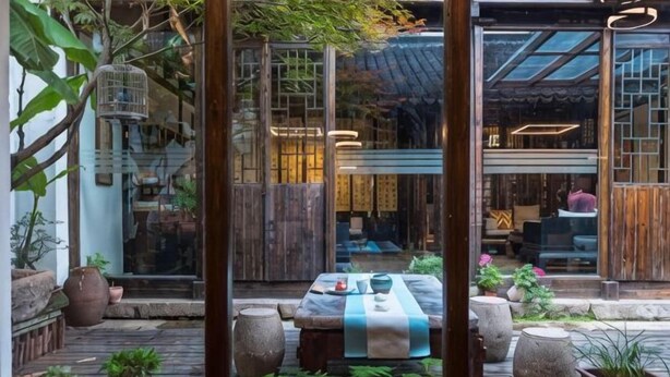 Un interior tradicional japonés con esteras de tatami, una mesa baja y una puerta corredera.