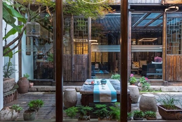 Un interior tradicional japonés con esteras de tatami, una mesa baja y una puerta corredera.