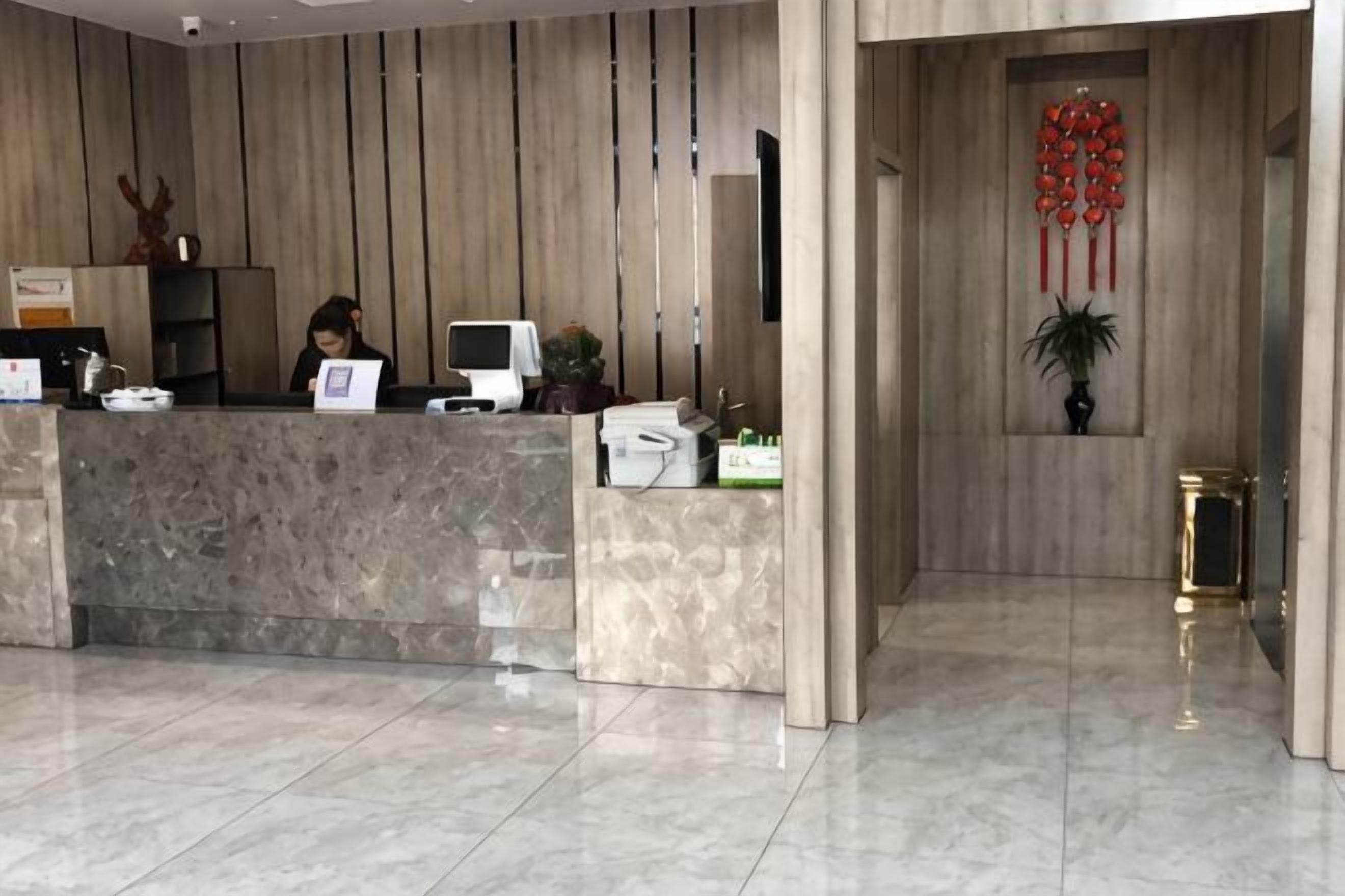 A reception desk with a computer, a telephone, and a plant.