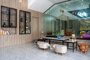 A modern interior with a glass wall, wooden shelves, and a seating area with a table and chairs. - Lanhao Boutique Hotel (Nantong)