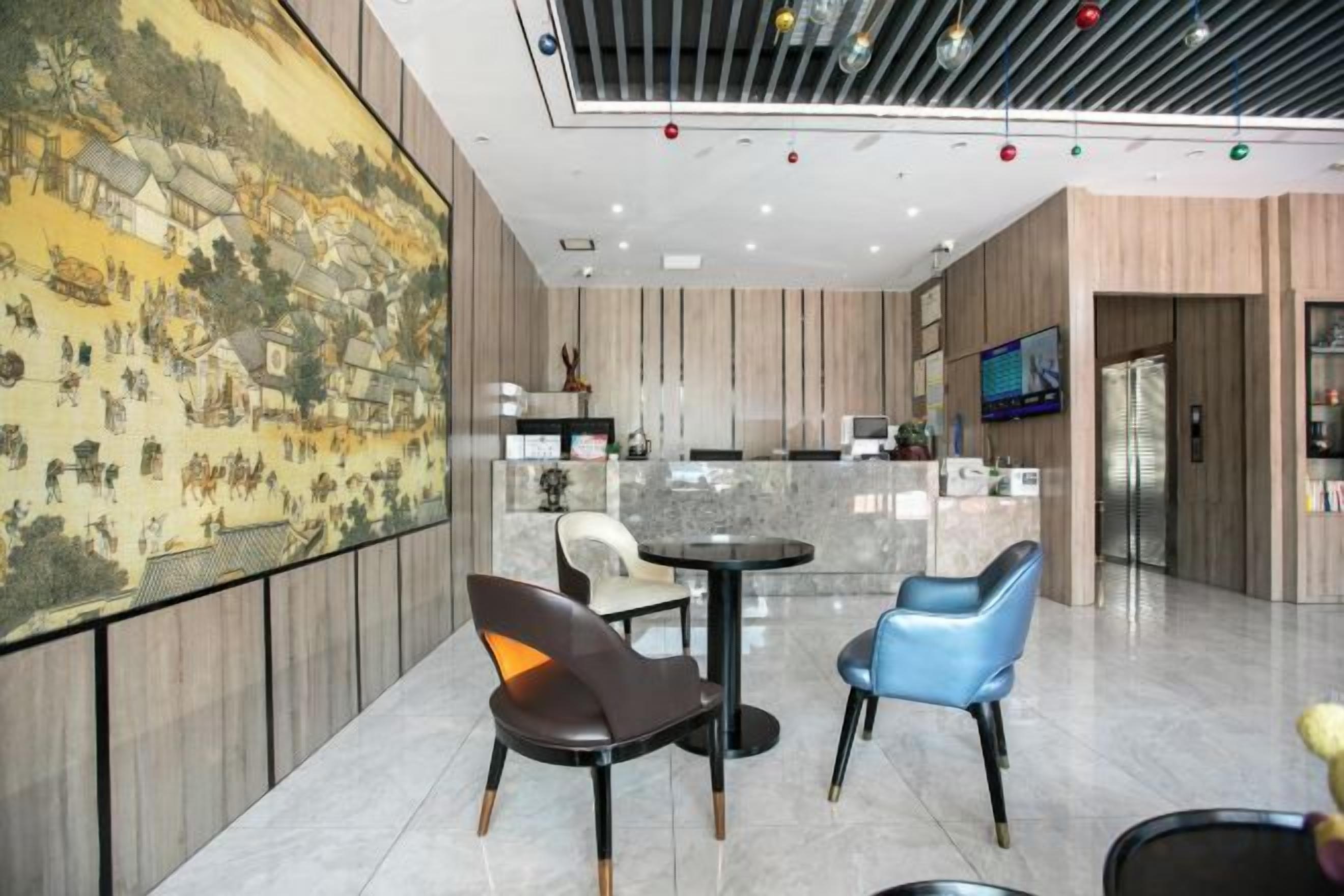 A modern interior with a dining area, a large wall painting, and a kitchen in the background.