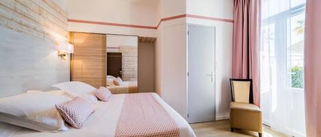 Una habitación de hotel con una cama grande, una silla, un espejo y una puerta.
