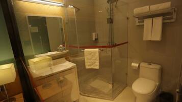 Uma casa de banho moderna com chuveiro envidraçado, sanita, lavatório com espelho e um porta-toalhas.