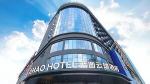 A modern hotel building with a curved facade and large glass windows. - Blueprint Cloud Hotel (Shenzhen Longcheng Plaza subway station store) (Shenzhen)
