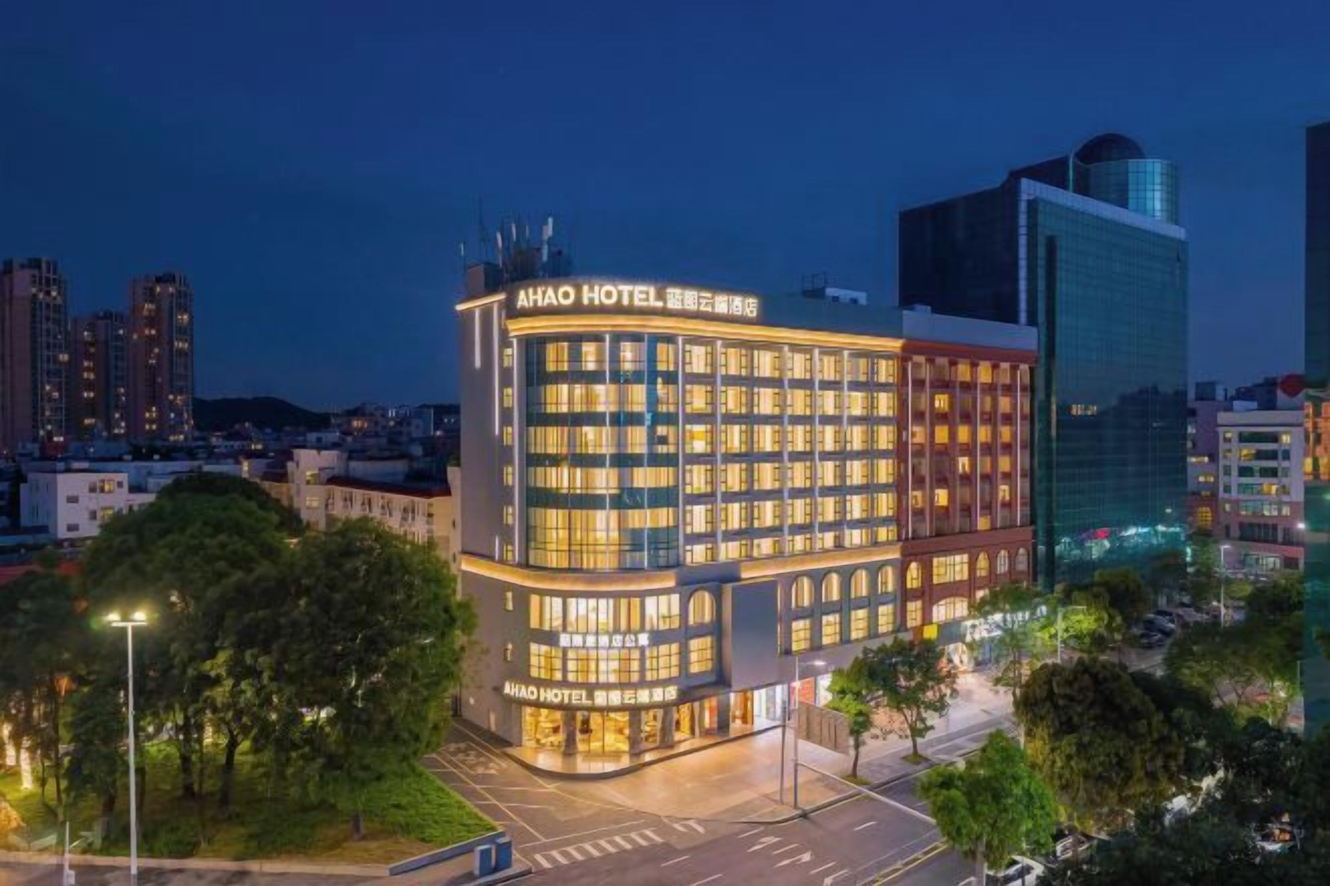 Un hotel de varios pisos con señalización llamativa, ubicación en esquina y diseño arquitectónico moderno.