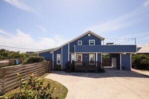 A two-story house with a front porch, a garage, and a covered outdoor area. - Casa Azul! Steps to ocean! Vilano beach! Pool, spa, oasis! Dog friendly! (St. Augustine)