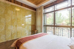 A bedroom with a large bed, a wooden ceiling, a window with a view, and a chair. - Nantong Jinwuye Leisure Homestay (Nantong)