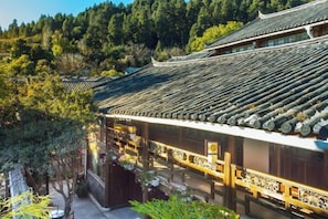 A traditional building with a tiled roof, surrounded by trees and vegetation.