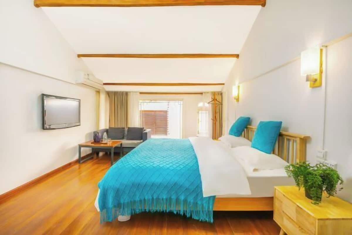 Une chambre à coucher avec un lit, une table de chevet et un téléviseur fixé au mur.