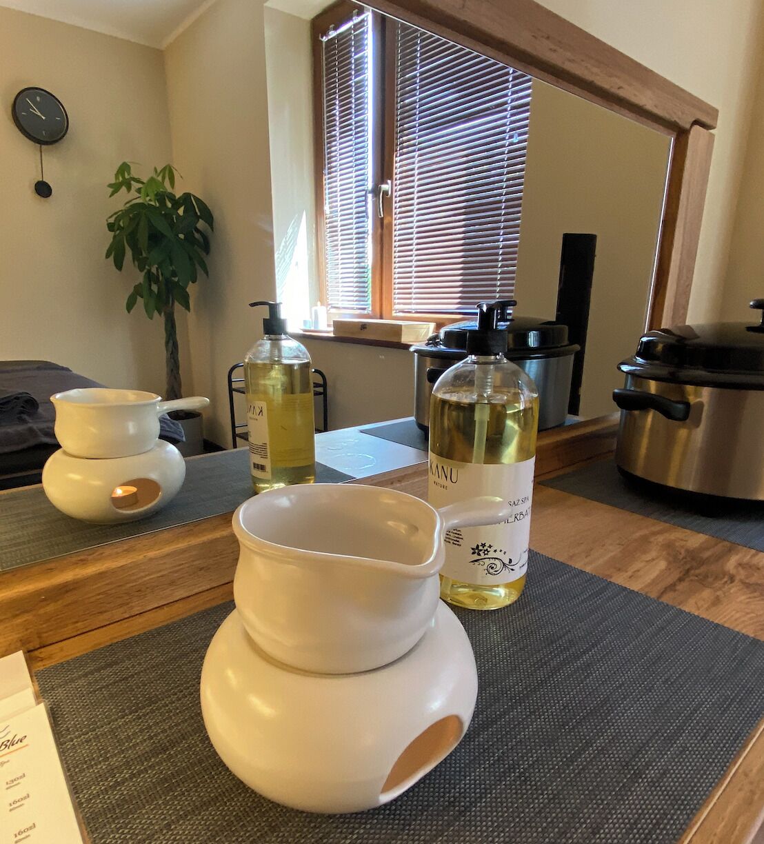 A kitchen with a wooden countertop, a white teapot, a bottle of KANU sake, and a stainless steel pot.