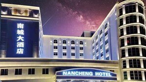 Un hotel con un letrero destacado que dice “NANCHENG HOTEL” y otro letrero en un idioma diferente.