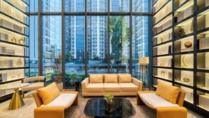 A modern interior with a sofa set, a coffee table, and shelves with decorative items. - Humgait Hotel (Hangzhou)