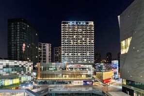 A high-rise building with a modern architectural design, featuring multiple floors and a prominent entrance. - Humgait Hotel (Hangzhou)