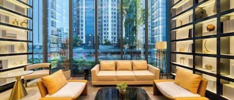 A modern interior with a sofa set, a coffee table, and bookshelves.