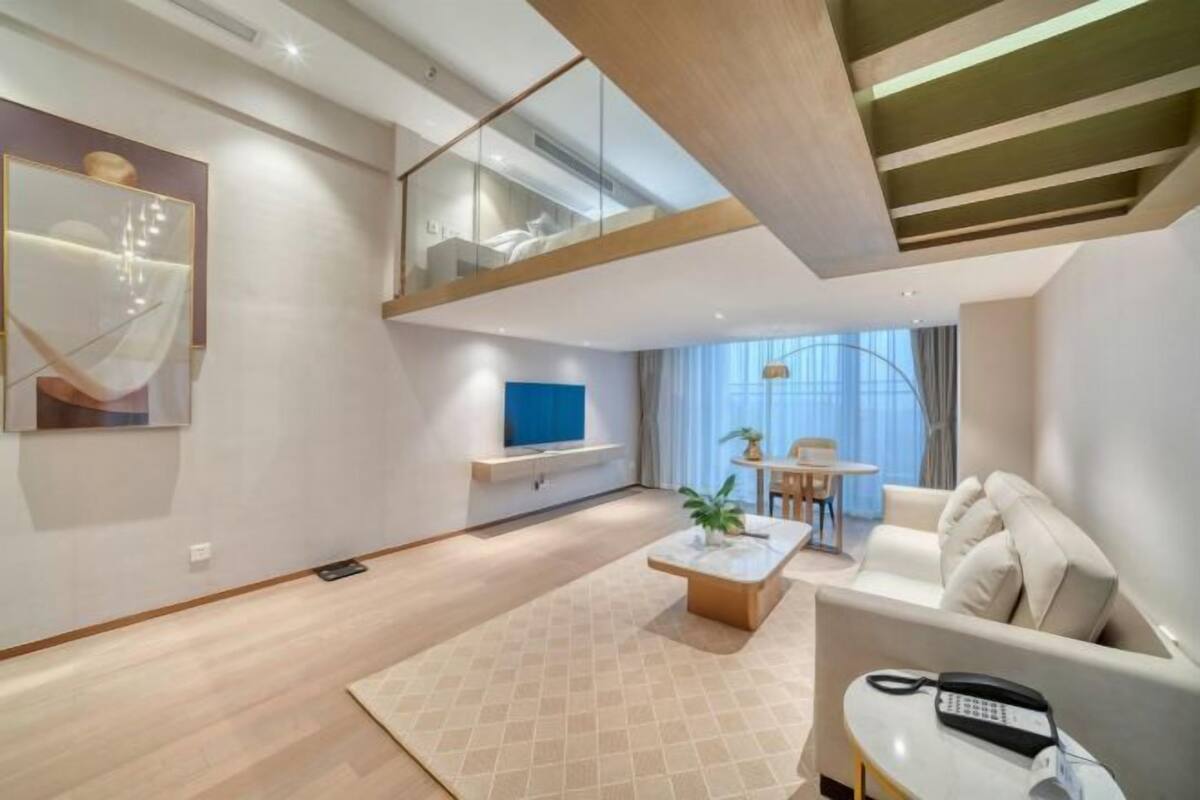 A modern living room with a sofa, coffee table, and a TV.