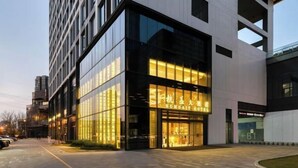 A modern hotel with a glass facade and a prominent entrance. - Humgait Hotel (Hangzhou)