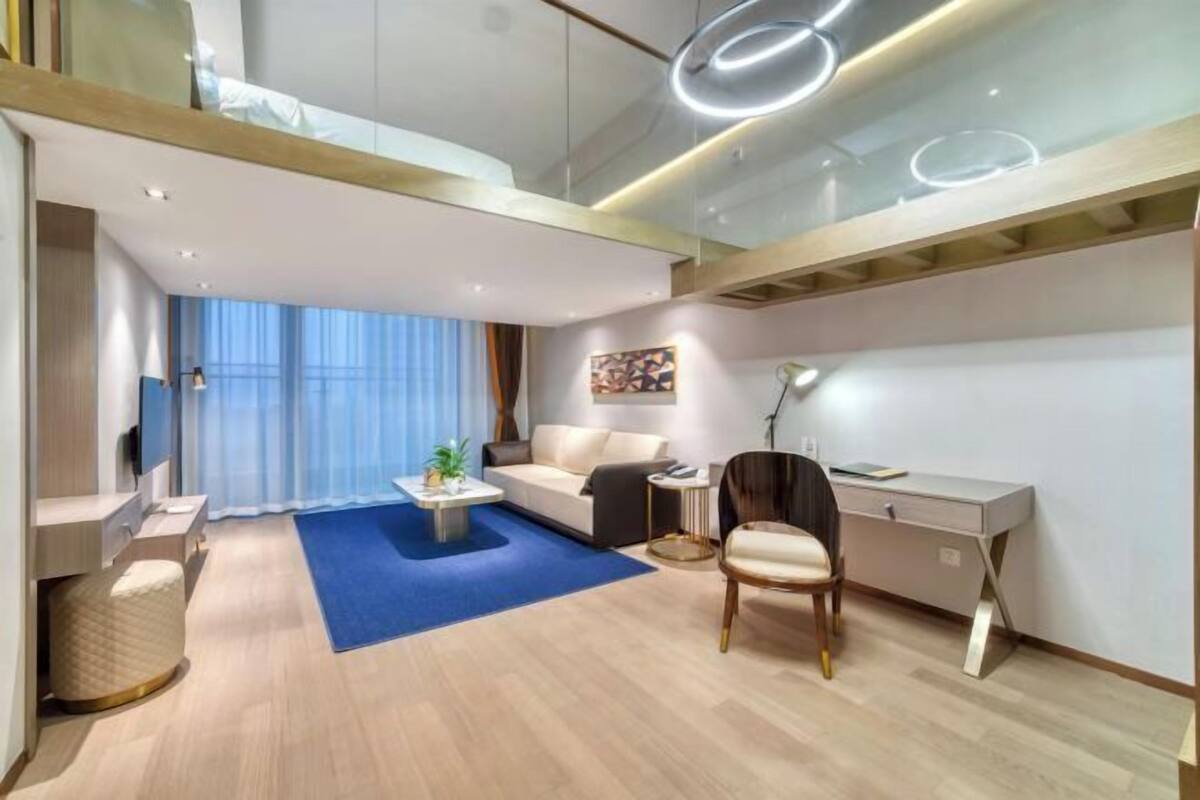 A modern living room with a sofa, coffee table, and a desk.