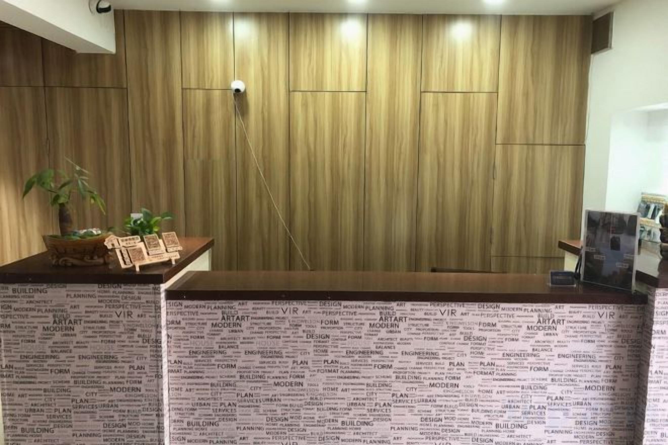 A reception desk with a wooden panel wall and a patterned counter.