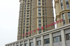 Un immeuble à plusieurs étages, sur lequel on peut voir une enseigne bien visible, avec des lettres rouges.