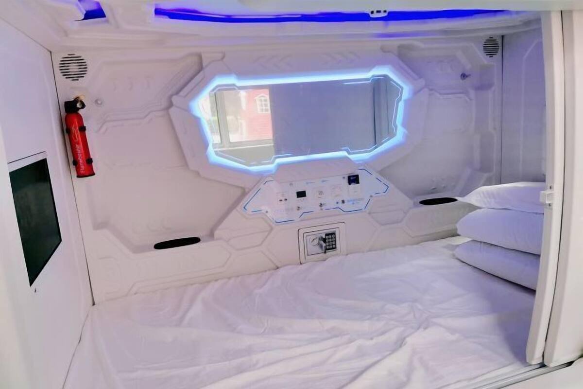 Une pièce comprenant un lit, un panneau de commande, un extincteur et une fenêtre.