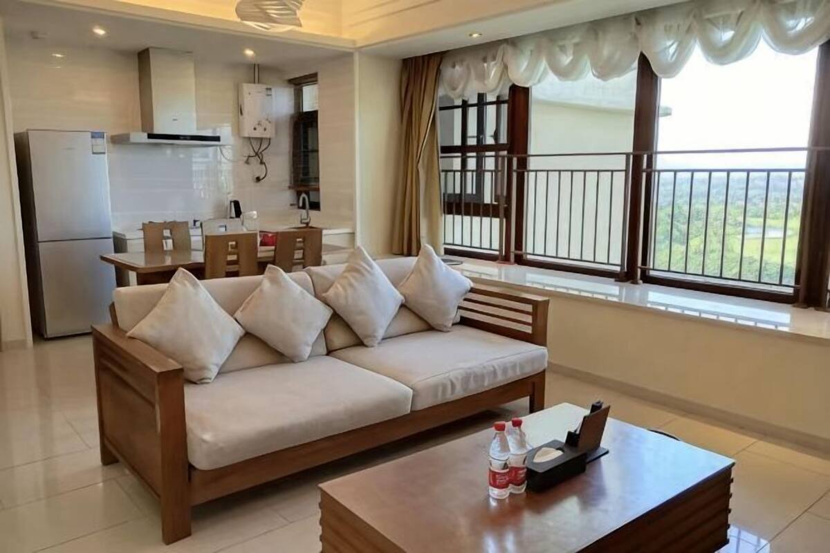 Een woonkamer met een bank, een salontafel en uitzicht op een balkon.