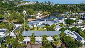 Un quartier résidentiel situé sur la côte, avec des maisons modernes, une marina et un lac.