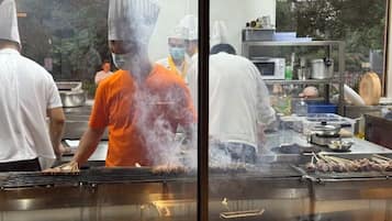 Een keuken met koks in actie, kookapparatuur en een roestvrijstalen werkblad.