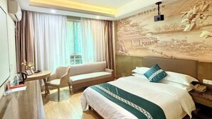 A hotel room with a bed, a desk, a chair, and a window with curtains. - Mango City Inn (Moon Lake Park North Metro · Window of the World Mango Pavilion) (Changsha)