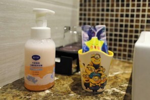 A bathroom with a soap dispenser and a mug with a Minion design. - Mango City Inn (Moon Lake Park North Metro · Window of the World Mango Pavilion) (Changsha)