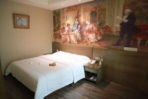 A hotel room with a large bed, a nightstand, a painting on the wall, and a small framed picture. - Mango City Inn (Moon Lake Park North Metro · Window of the World Mango Pavilion) (Changsha)