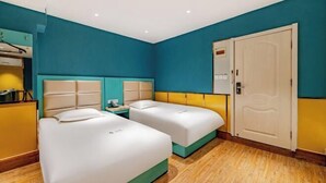 Una habitación de hotel con dos camas, un armario y una puerta.
