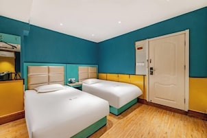 Una habitación de hotel con dos camas, un armario y una puerta.