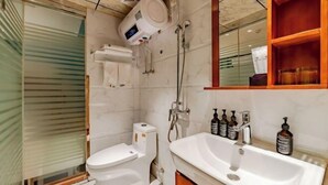 Un baño moderno con inodoro, bidé y un lavamanos grande con espejo.