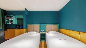 Una habitación de hotel con dos camas, un escritorio pequeño y un armario.