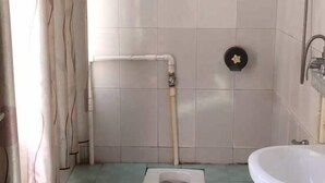 Une salle de bain comprenant des toilettes, un lavabo et un espace douche.