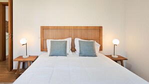Ein Schlafzimmer mit einem großen Bett, zwei Nachttischen und einem Holzkopfende.