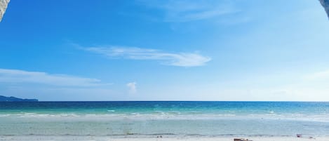 Una playa con agua azul cristalina y arena blanca.