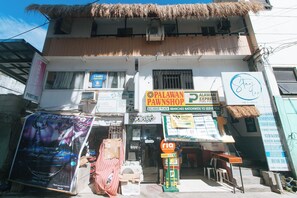 Un edificio con varios negocios, entre ellos una casa de empeño, una imprenta y un banco.