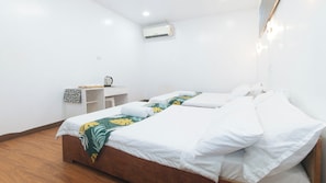 A hotel room with two beds, a desk, and an air conditioning unit. - Stay Inn Station 1 Boracay By Reddoorz (Boracay Island)