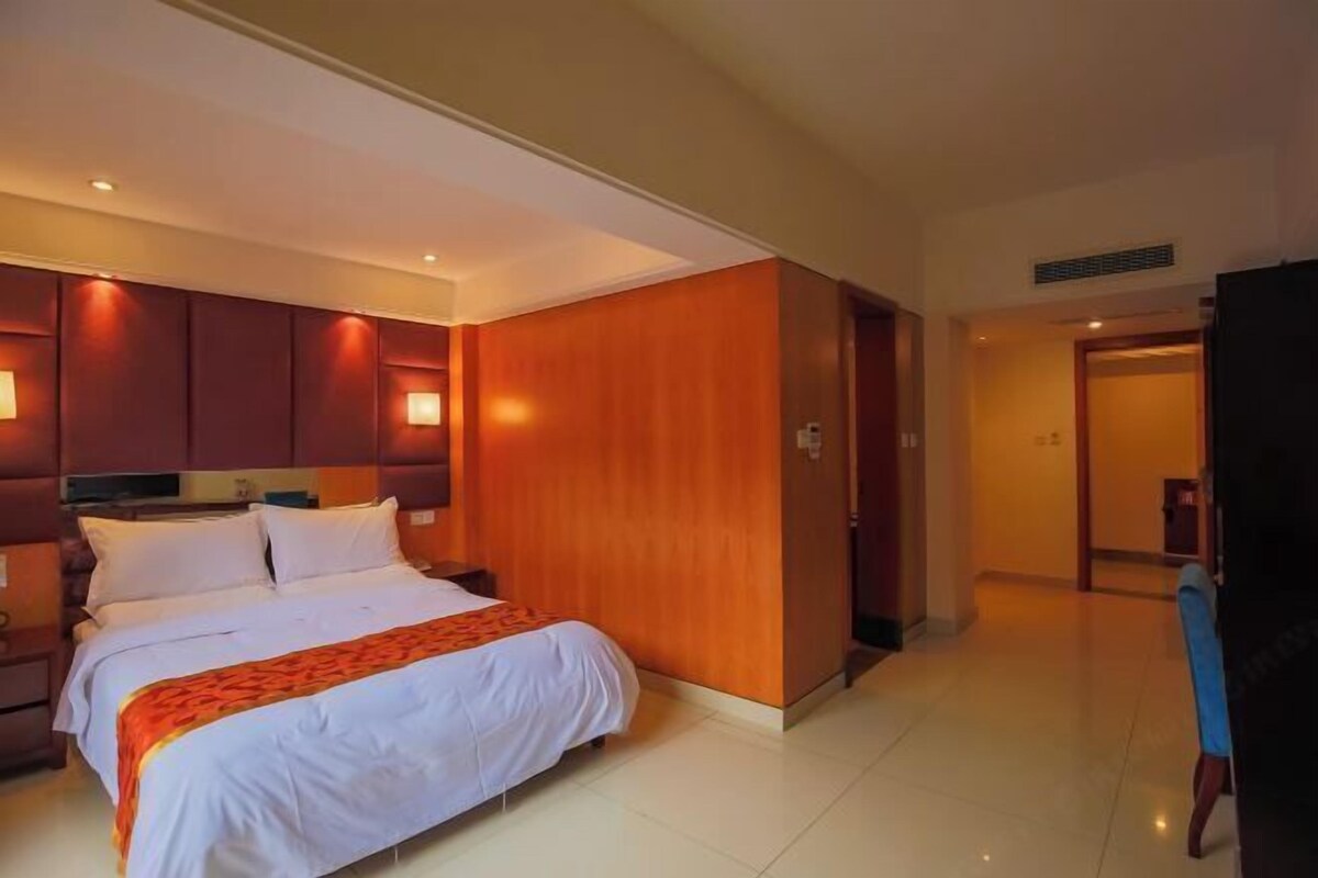 Ein Hotelzimmer mit einem großen Bett, einem Holzkopfteil und einem Kleiderschrank.