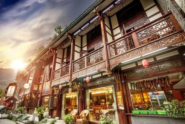 Un bâtiment traditionnel en bois, doté de balcons et abritant un magasin au rez-de-chaussée.