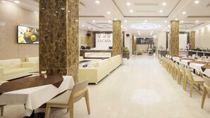 A hotel lobby with a reception desk, seating areas, and a long dining table. - La Casa Hotel Nha Trang (Bac Nha Trang)