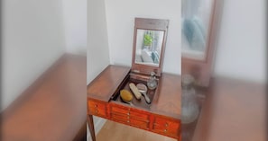 A small wooden vanity with a mirror, a brush, a magnifying glass, and a salt shaker. - Scandi Style Maisonette with Garden, Shoreditch (London)