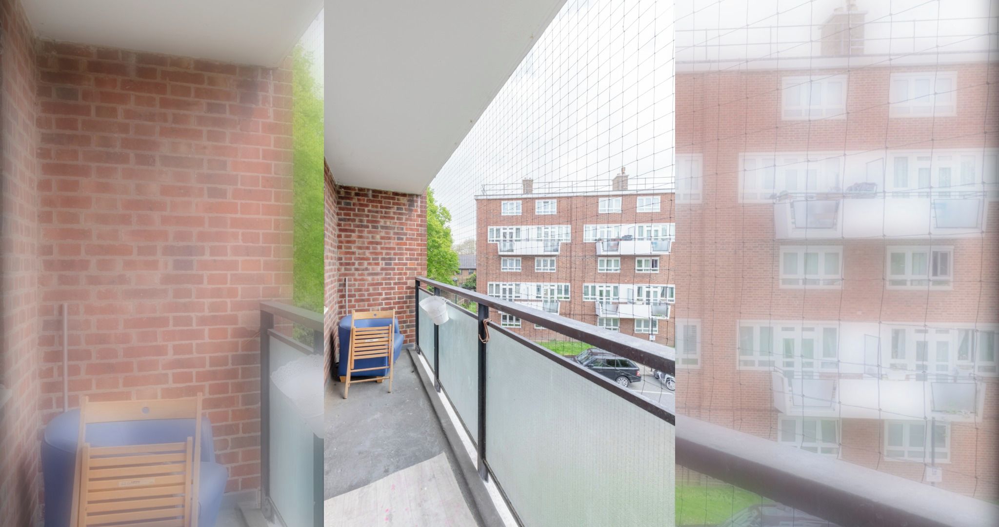A balcony with a view of a brick building, a blue chair, and a suitcase.