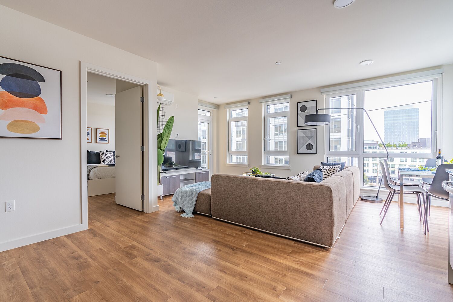 A modern apartment with a living room, dining area, and kitchen.
