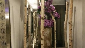 A corridor with tall, slender trees and purple flowers. - Zunyi Hengsheng Hotel (Yuqing)