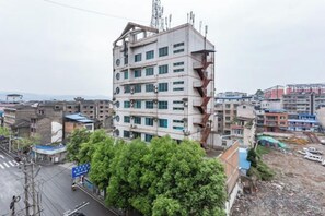 Un edificio de varios pisos con una fachada deteriorada y un escape de incendios visible.