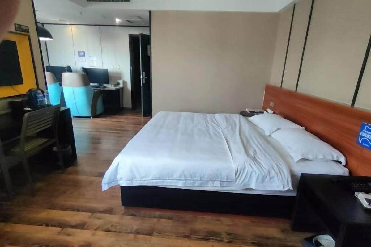 A hotel room with a bed, a desk, and a chair.