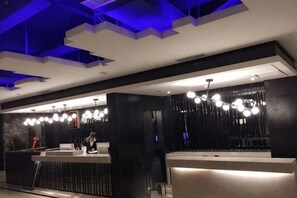 A hotel reception area with a modern design, featuring a reception desk, seating area, and a chandelier. - Zunyi Hengsheng Hotel (Yuqing)