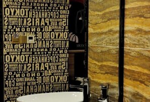 A bathroom with a sink and a mirror. The wall has text in various orientations. - Zunyi Hengsheng Hotel (Yuqing)